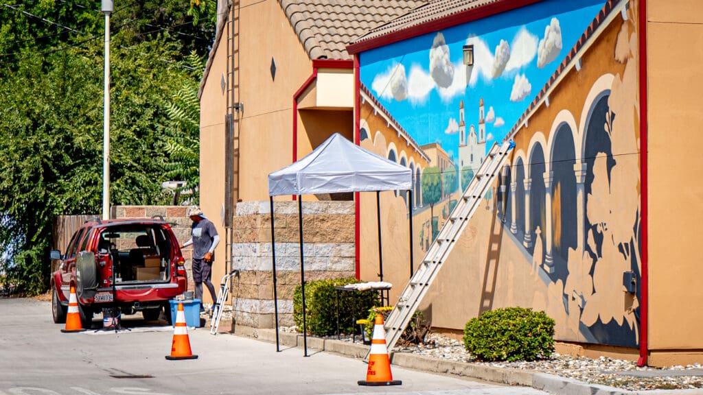 A ladder rests up against a mural