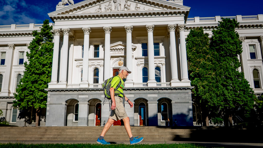 man walking in front of state capitol