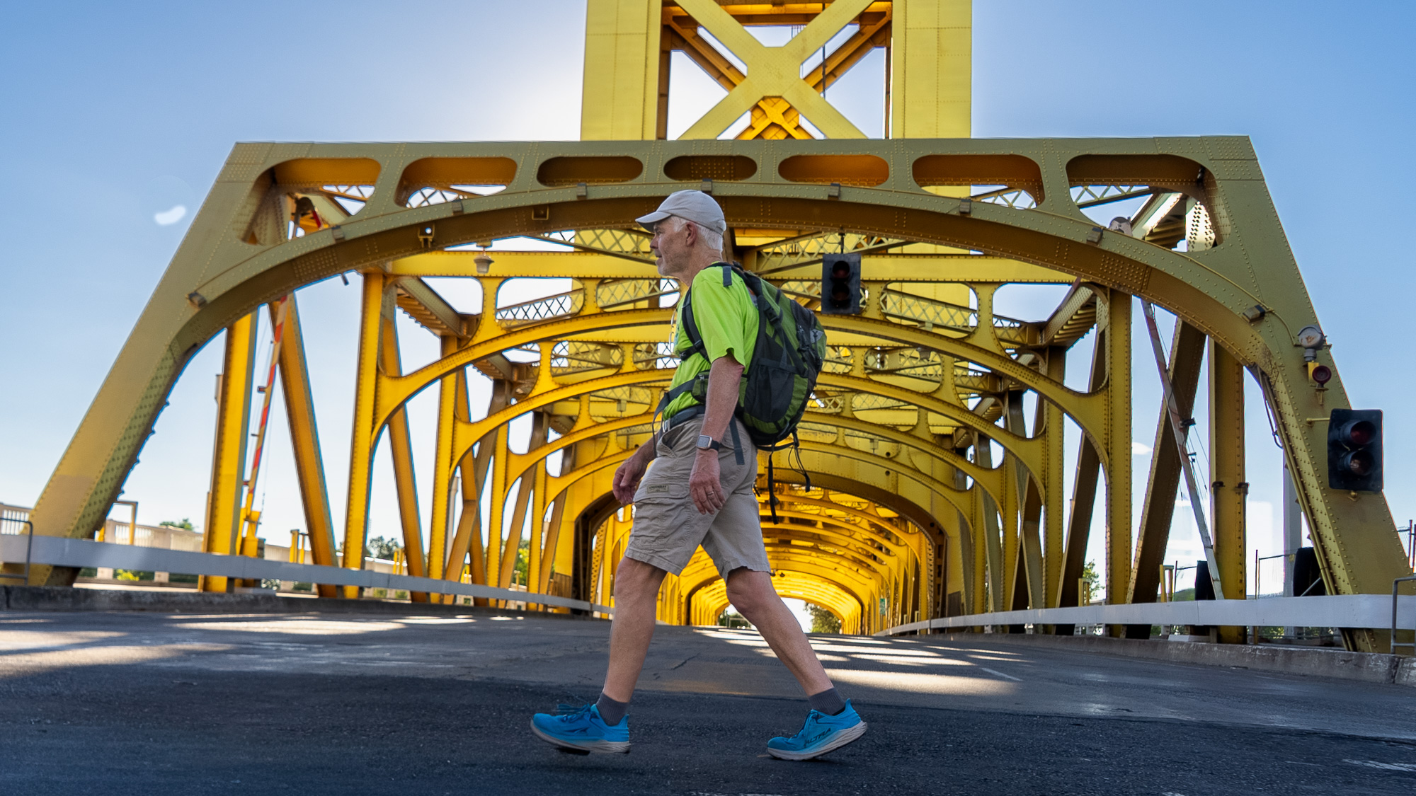 man walking in front of bridge
