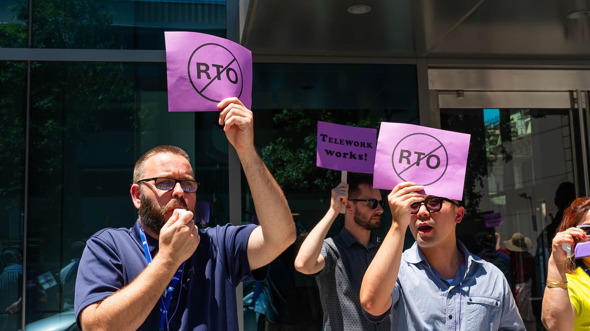 Workers hold up signs