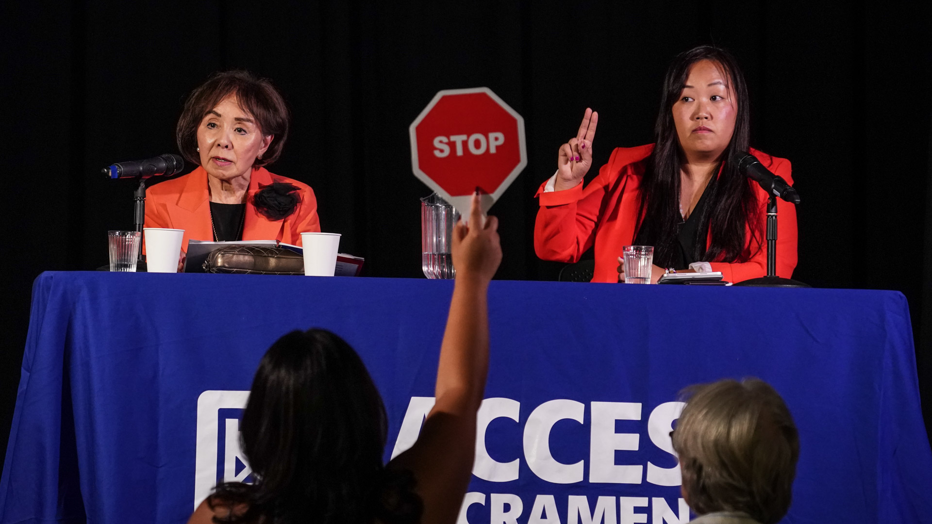 Woman holding stop sign at a debate