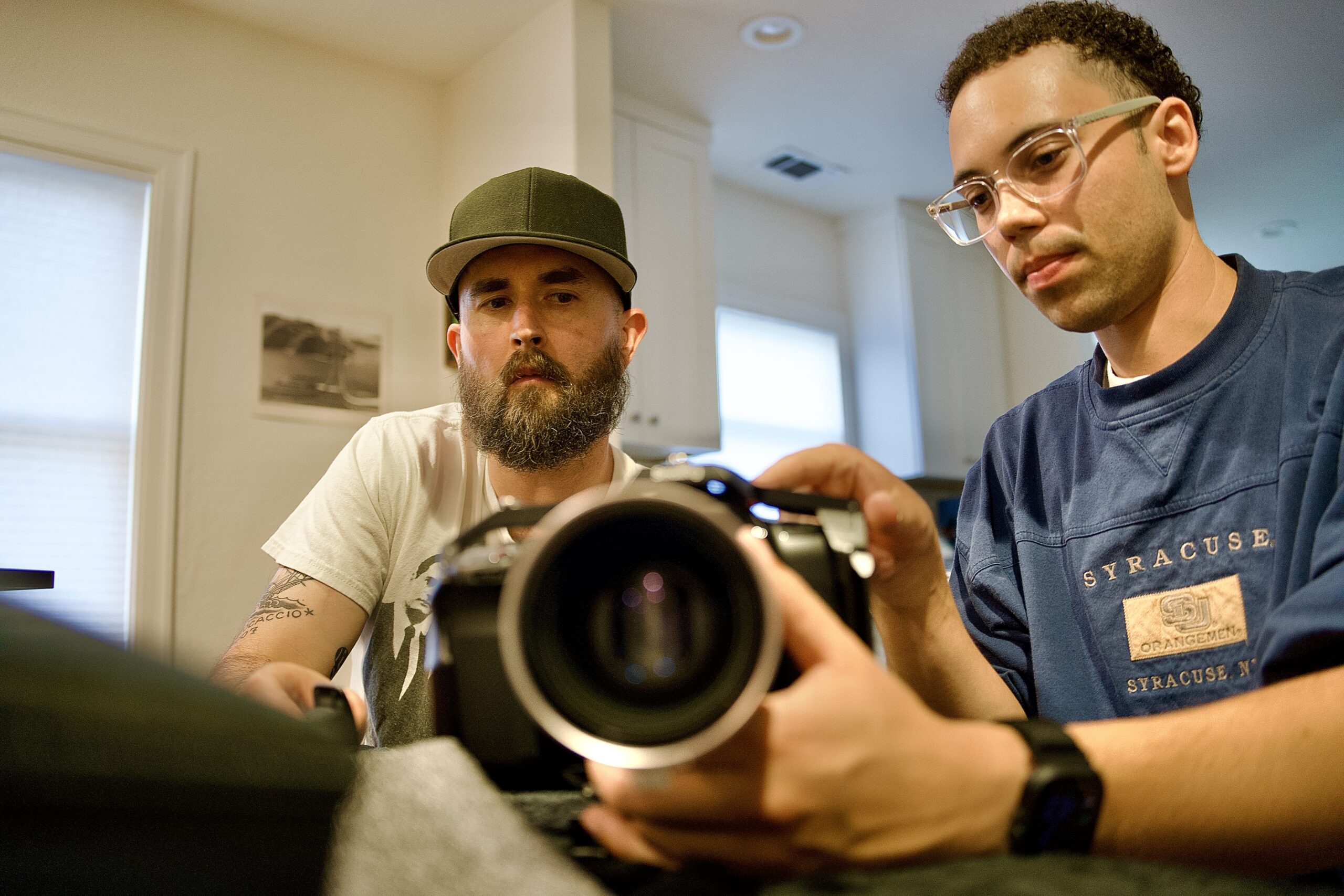 Two men hold a camera