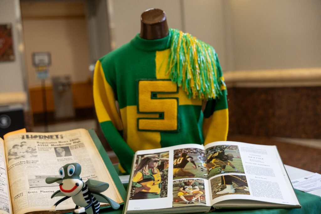 Display of Sac State Hornet sweater and yearbooks on a table.
