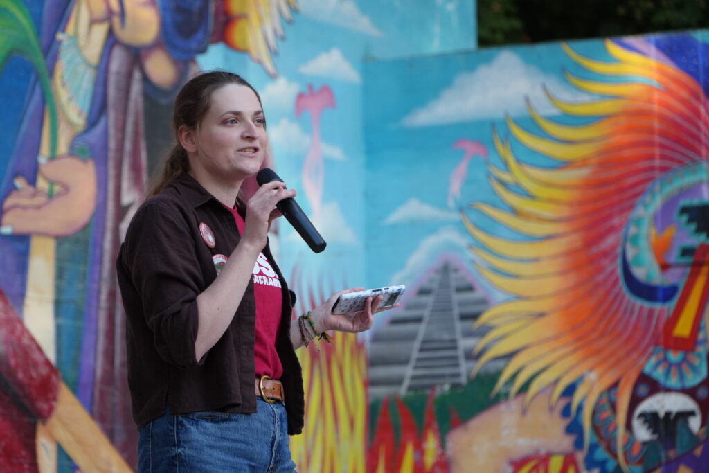 woman in brown jacket with microphone