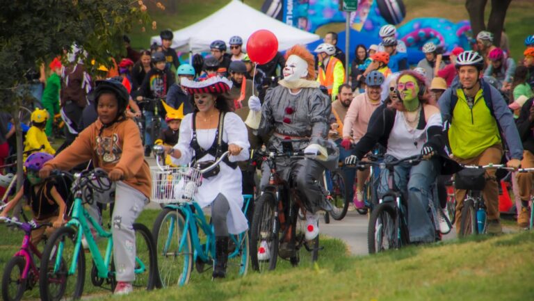 People in costume ride bikes